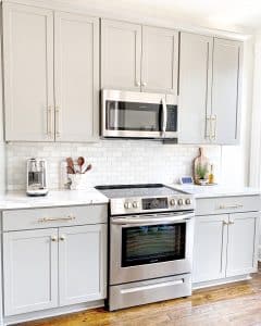 Light grey kitchen cabinets with gold accents